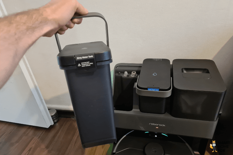 The dirty water tank from the Roborock S7 MaxV Ultra Station is held in the hand with the help of a carrying handle.